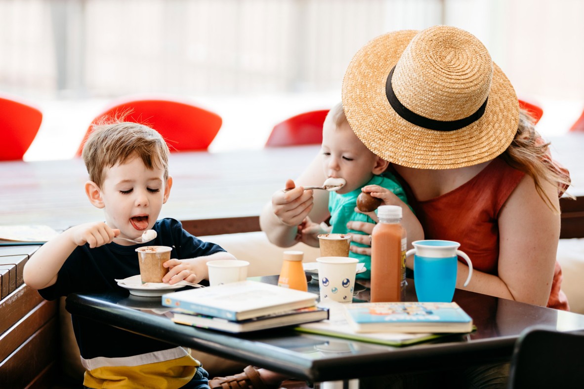 Woman with two young children with hot chocolates at the Library Cafe. 