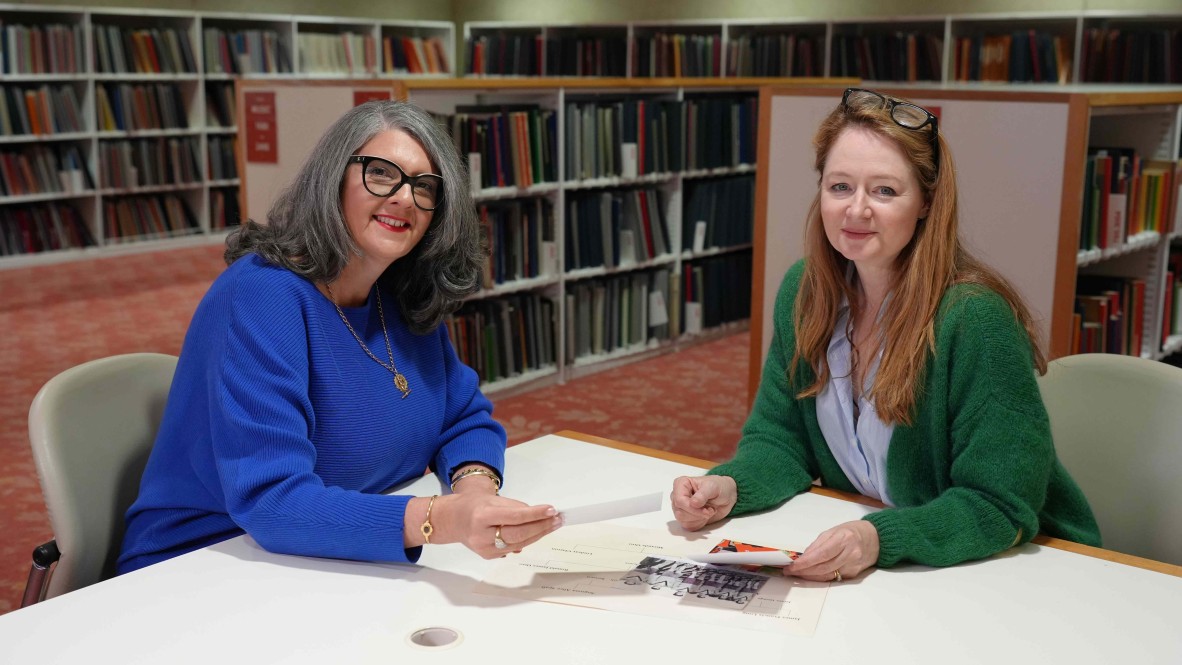 Two women sitting at a library table