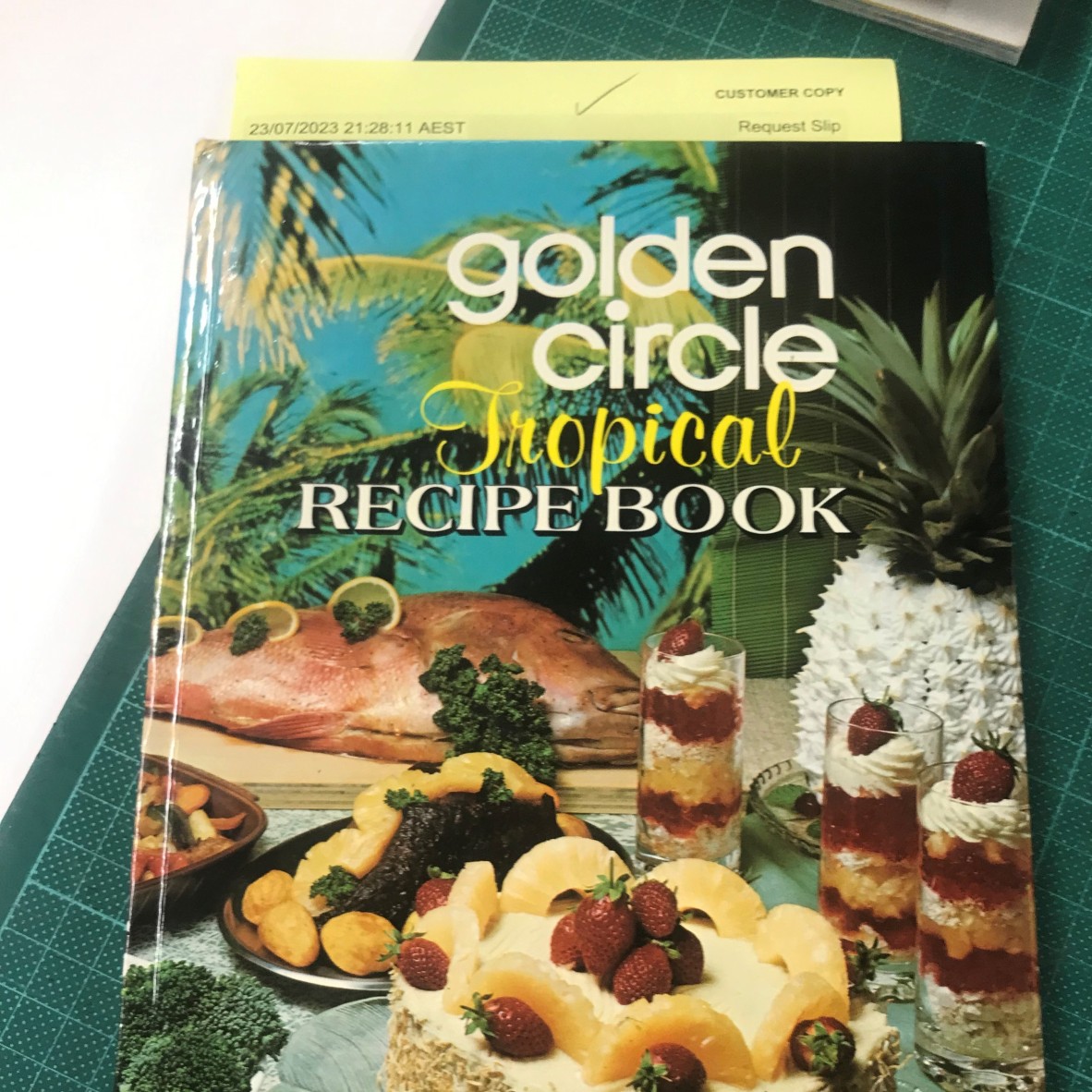 Book cover with pineapple recipes. Text reads Golden Circle Tropical Recipe Book