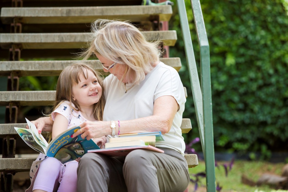 Grandmother reading outside with her grandchild