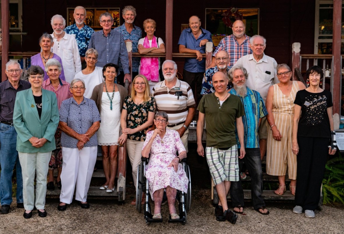 a large group of people stand infront of a building 