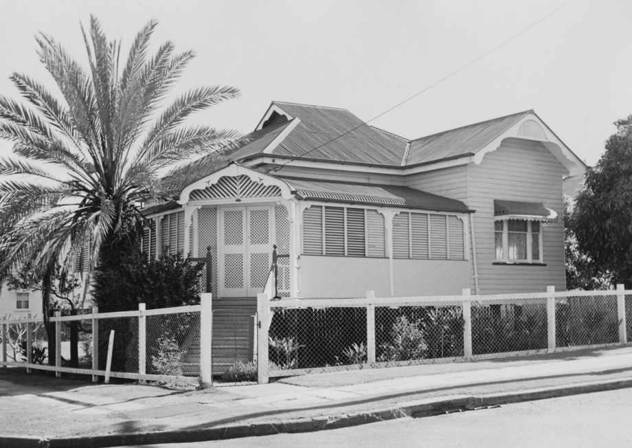 A picture of a house with a fence and a palm tree out the front at Stones Corner