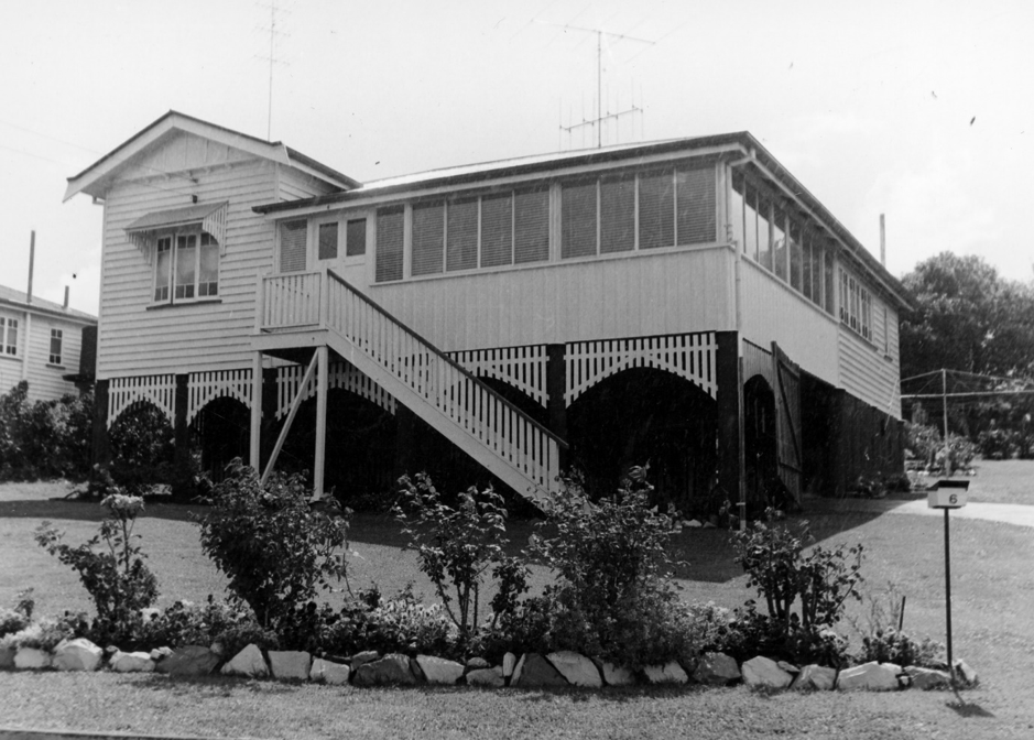 Picture of a house with a long front stairway and rose bushes in Gympie