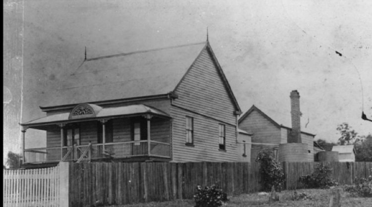 Picture of a small house with a raised verandah and a fence