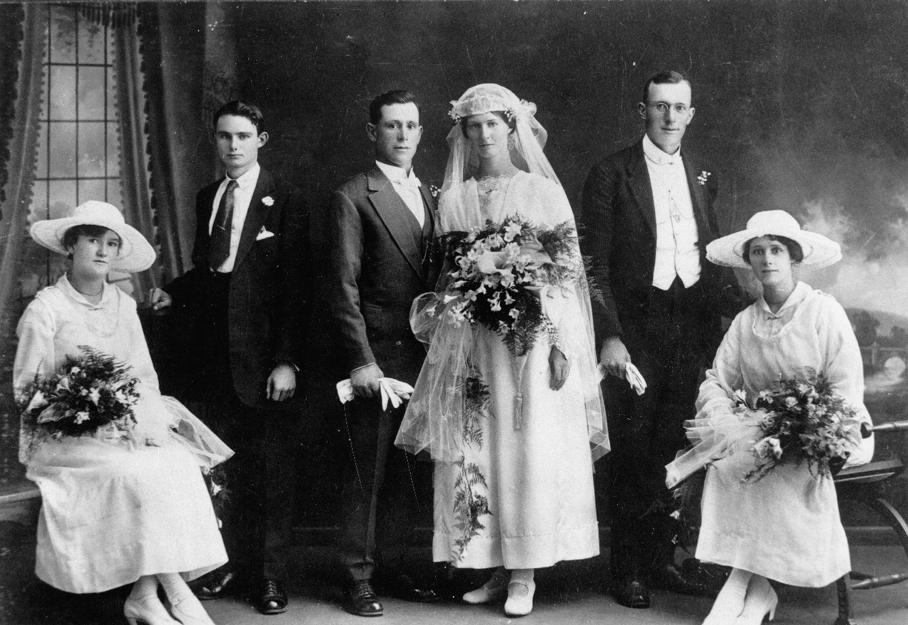 A black and white photograph of a wedding party from the early 1900s