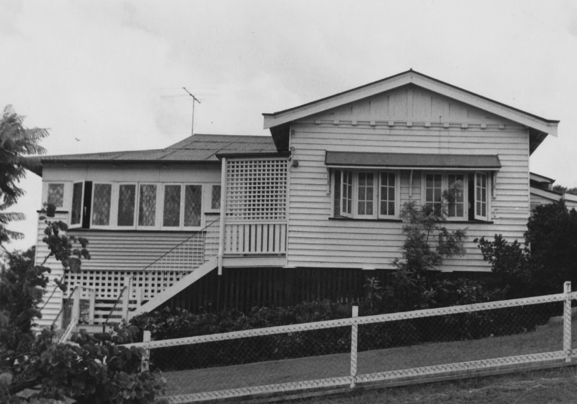 Black and white photograph of a house with stairs and a fence in Wilston