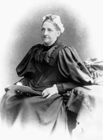 Black and white photograph of a lady sitting down in a layered dress
