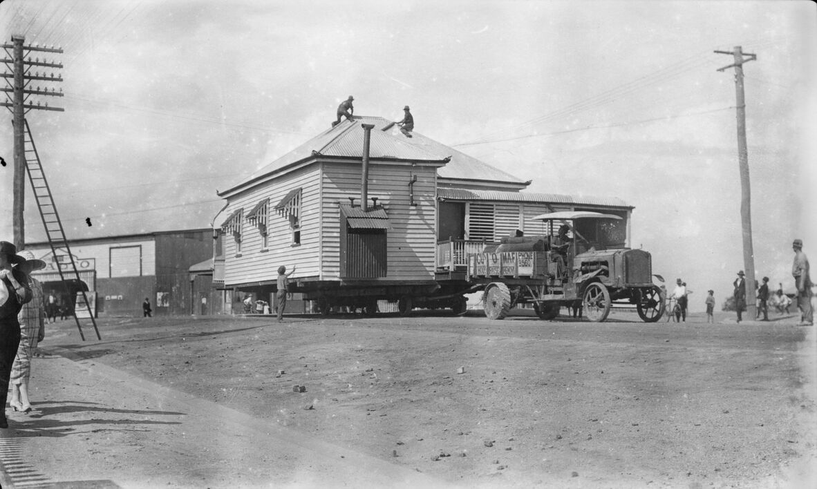 House being moved by a Renard road train engine on a suburban street, North Ipswich