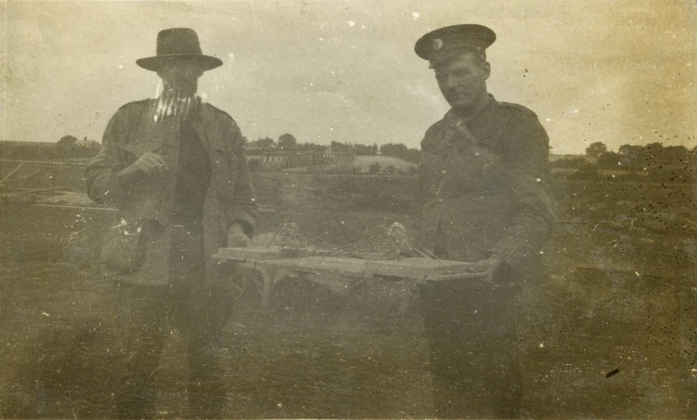 Photo of Lieutenant Hugh Campbell and another man holding a scale model of a temporary bridge