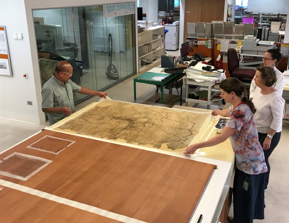 Conservators Eddie Jose and Jennifer Loubser transfer the map onto karibari for flattening