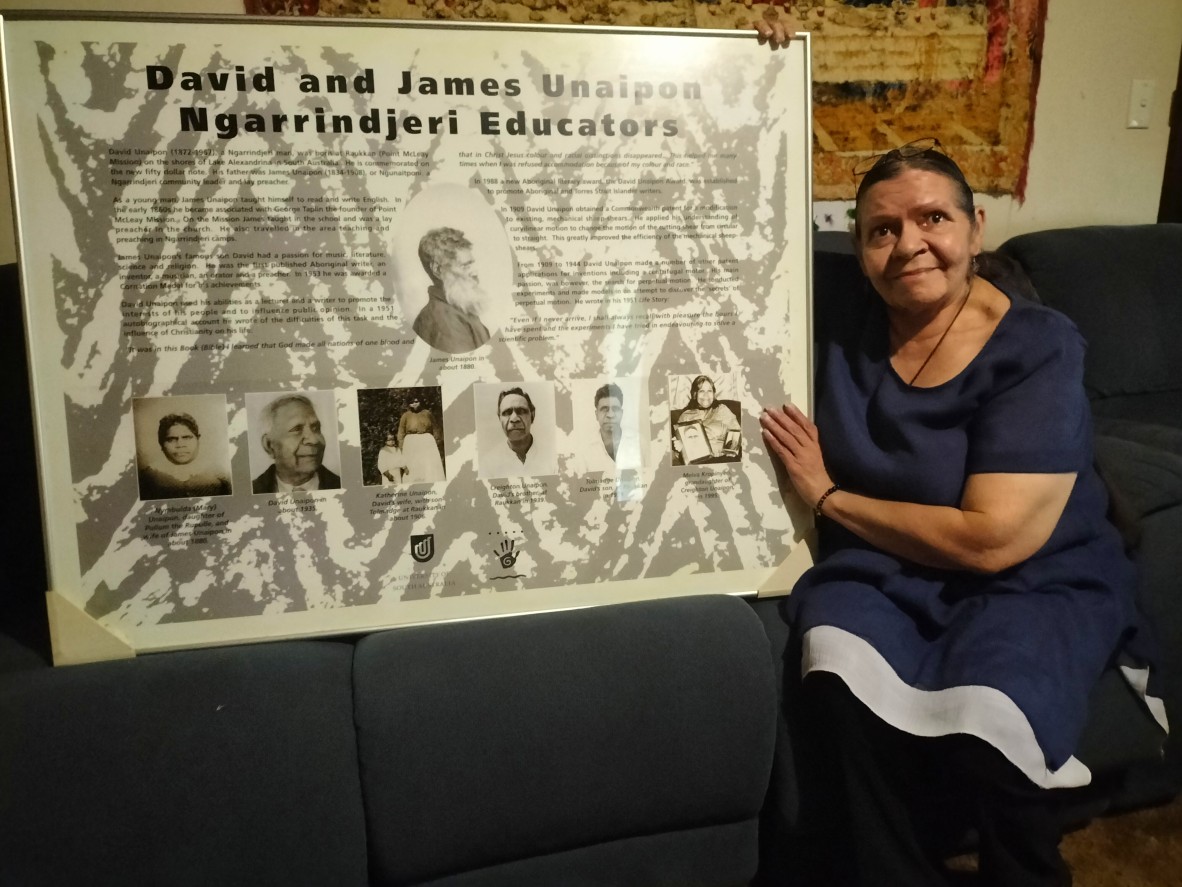 Ngarrindjeri Elder Aunty Elaine Kropinyeri sits beside a framed history of her great-uncle David Unaipon