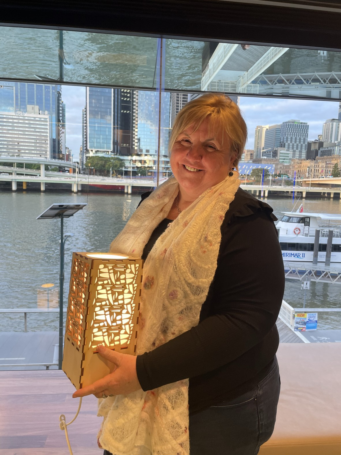 Photo of a woman holding a laser cut lamp