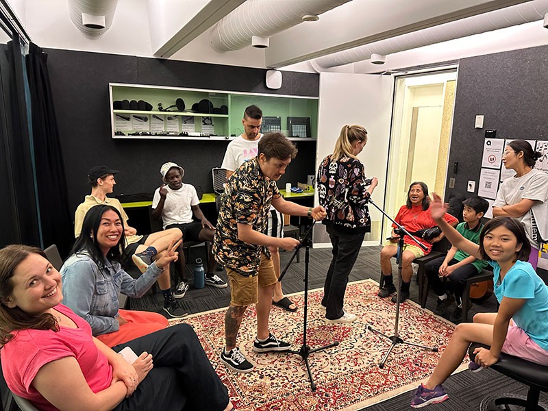 People setting up microphone is recording studio