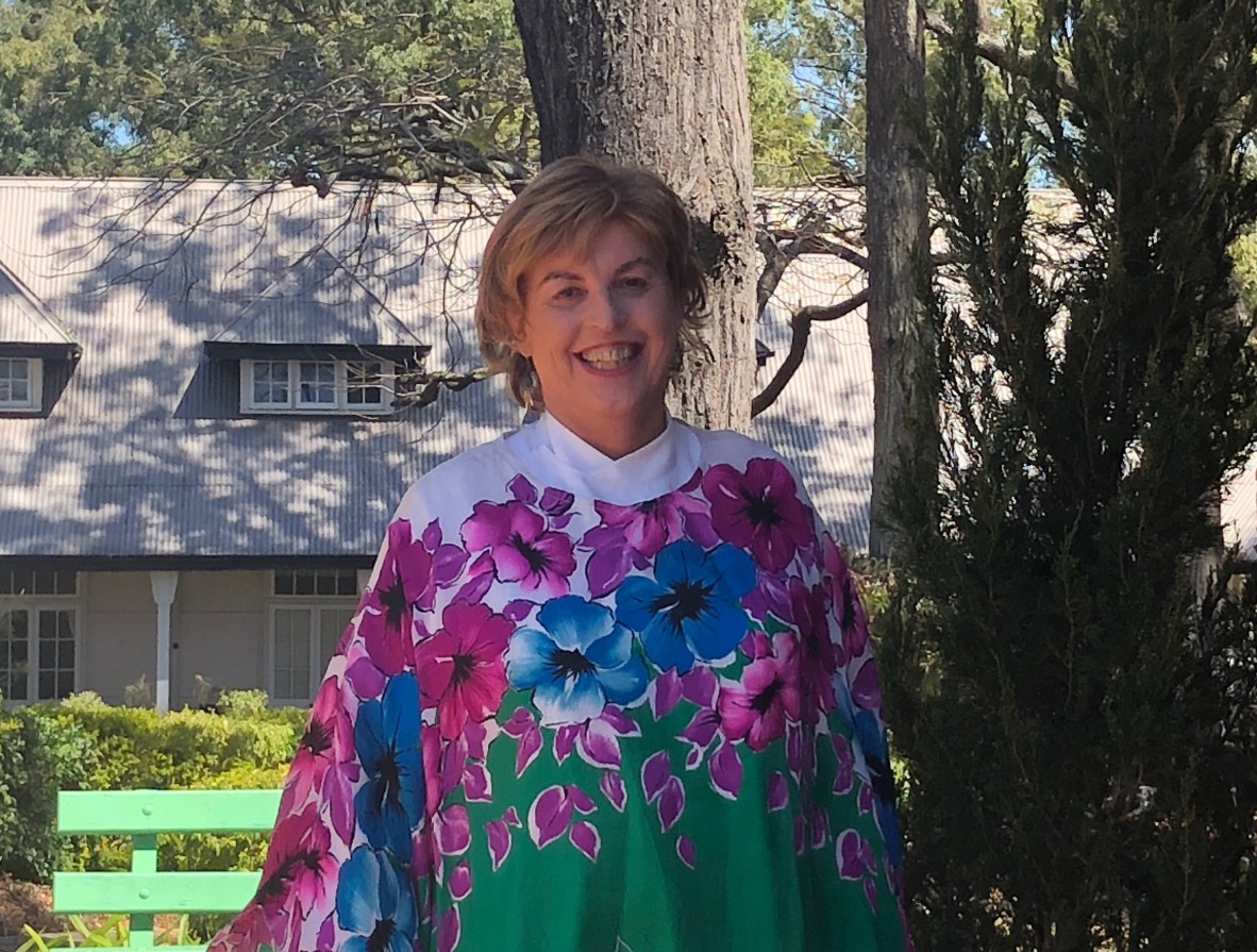 Rev Dr Josephine Inkpin in her Anglican robes standing outside smiling