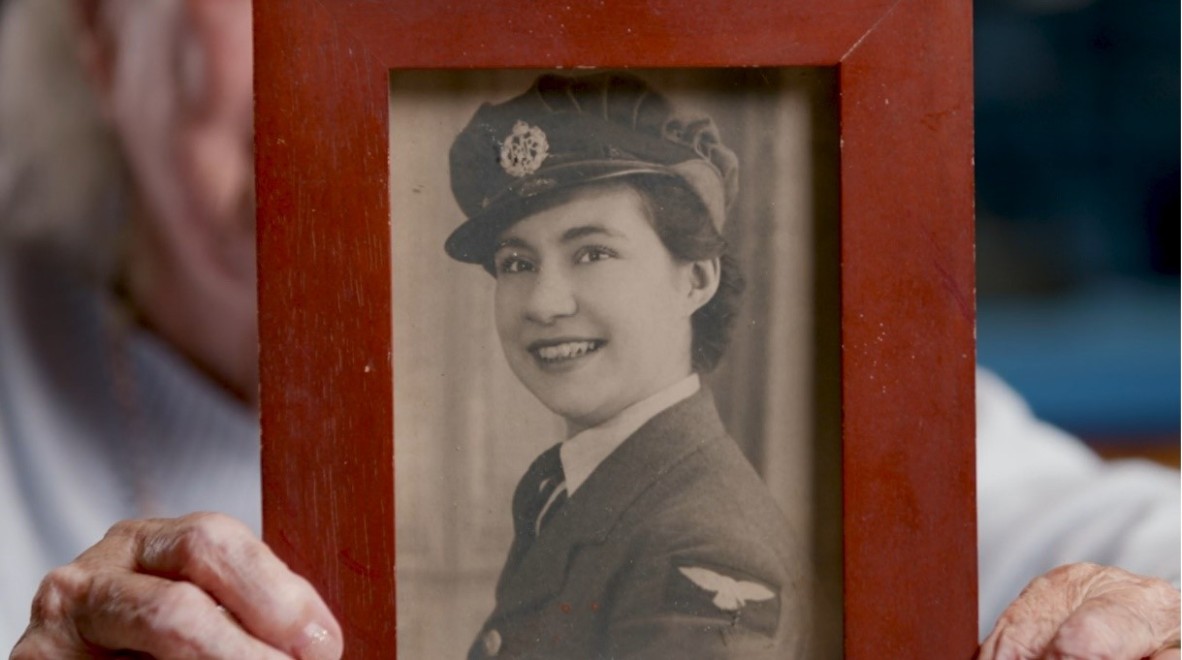 Jackie McLaughlin holding a photograph of herself when she enlisted in the British Womens Auxiliary Air Force
