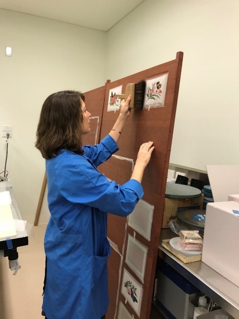 Conservator Jennifer Loubser with pith paintings on Karibari. Conserved September 2020