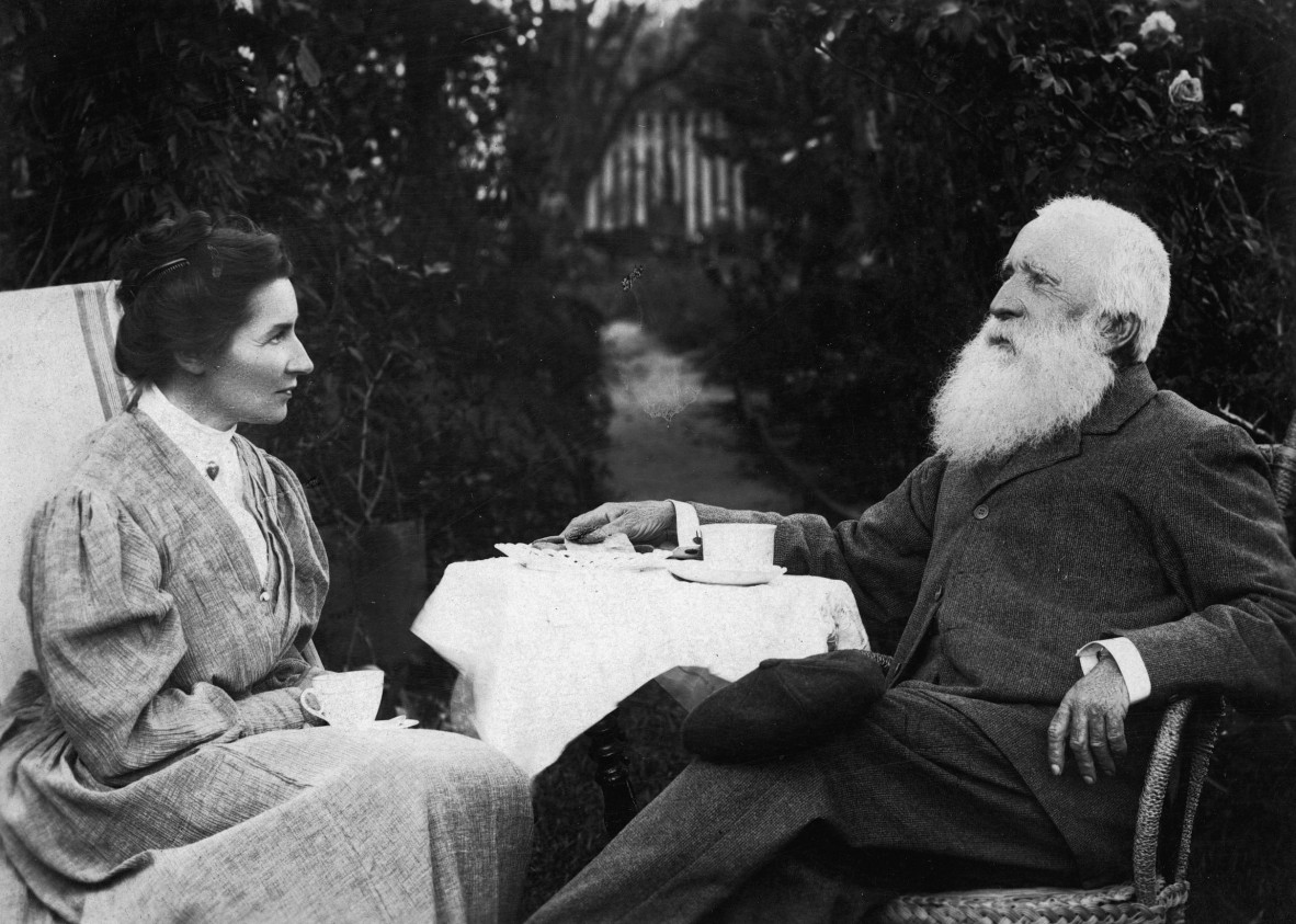 Black & white photo of a woman and a man sitting with a small table between them