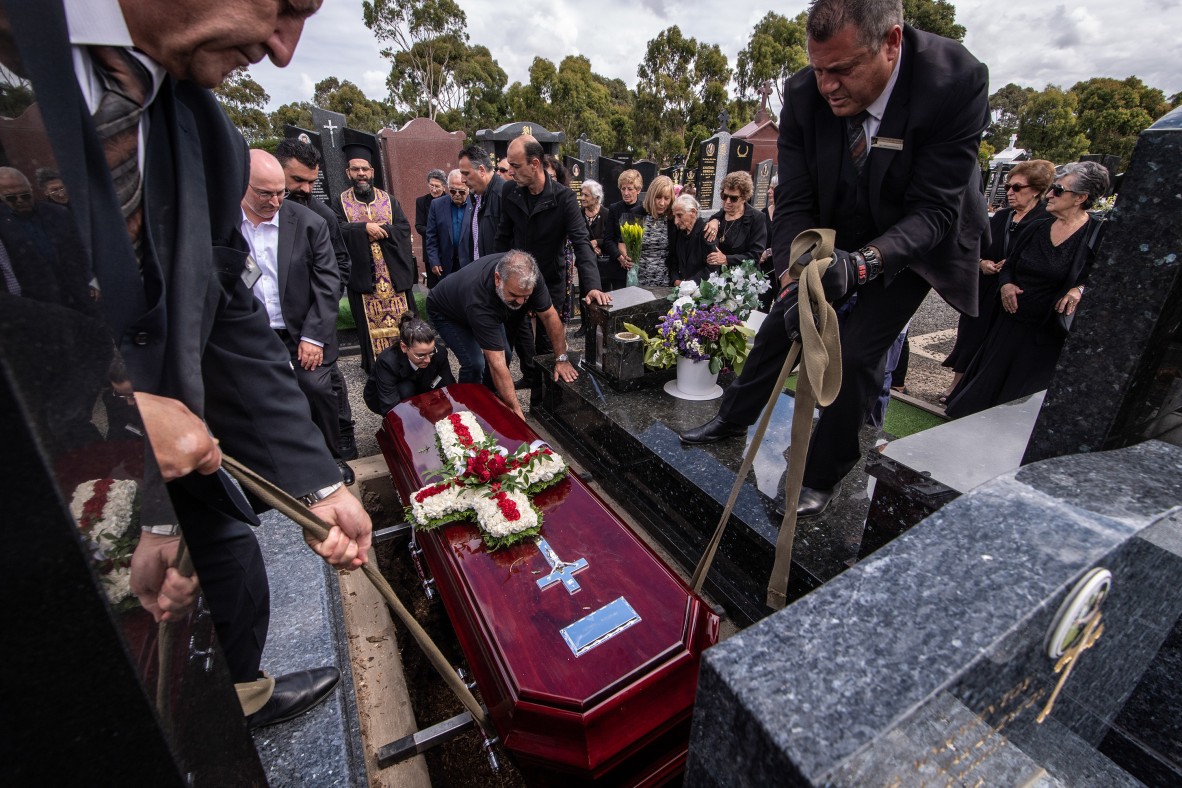 A photo of a coffin being lowered into a grave