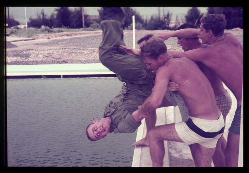 Australian in shorts throwing a fellow soldier into a river, Vietnam, 1968-69.