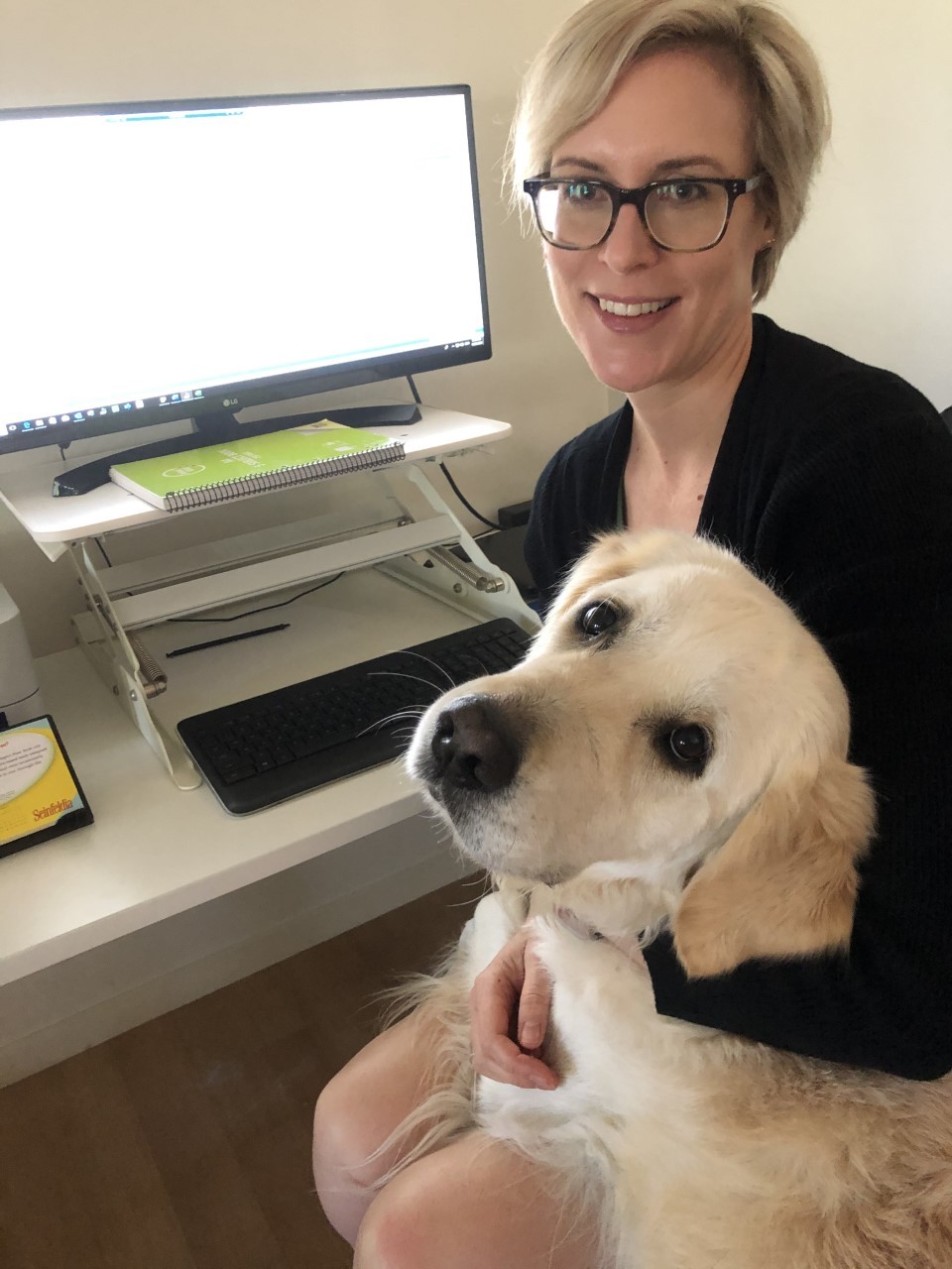 Library technician Kristina Read and her dog Moose working from home - sitting at a computer together