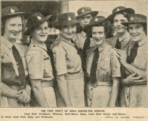 A group of Land Army women pose for a photograph, text reads "The first party of girls leaves for Ipswich"