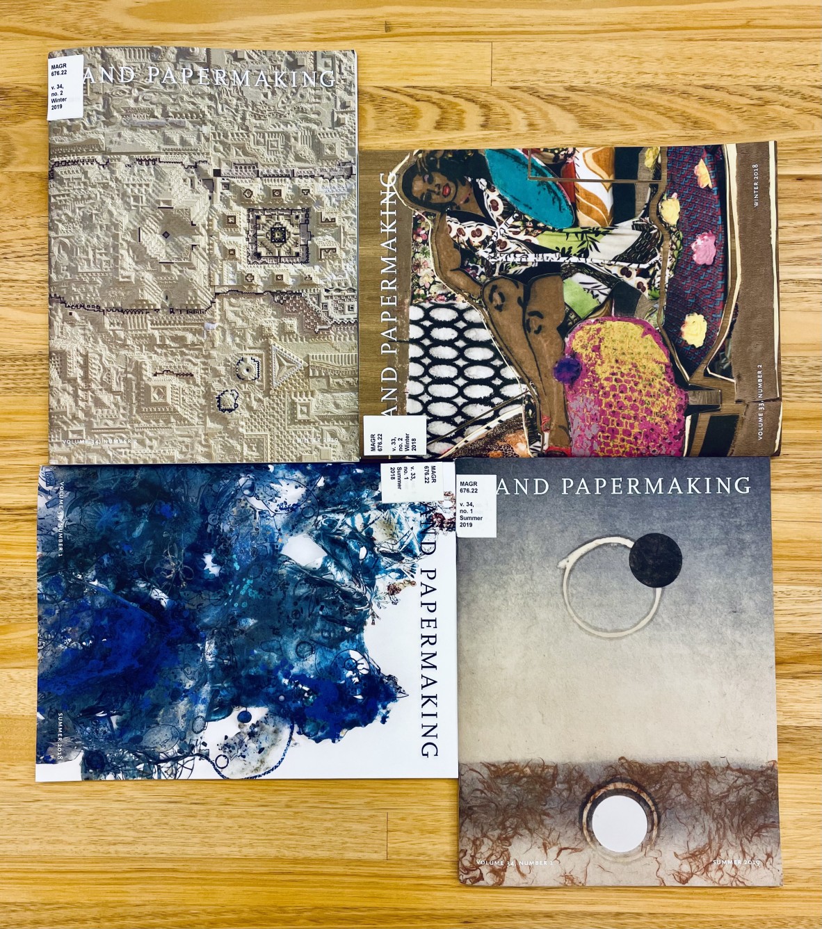 Image of four front covers for the magazine Hand Papermaking displaying different types of paper