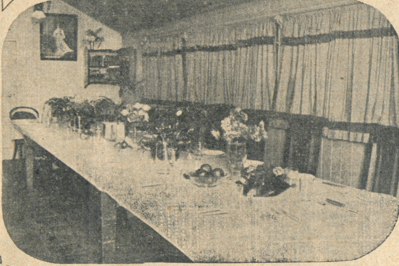 Dining room at Longa Linga with long table and chairs down one side and vases of flowers along the table.