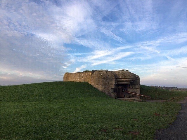 Photo of bunker in green hill overlooking beaches at Normandy