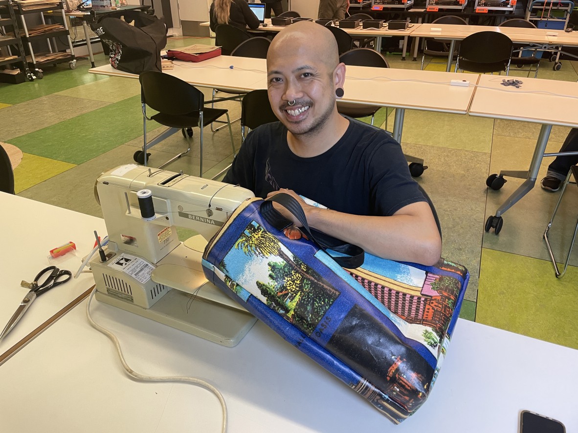 Photo of a person sewing a recycled vinyl bag