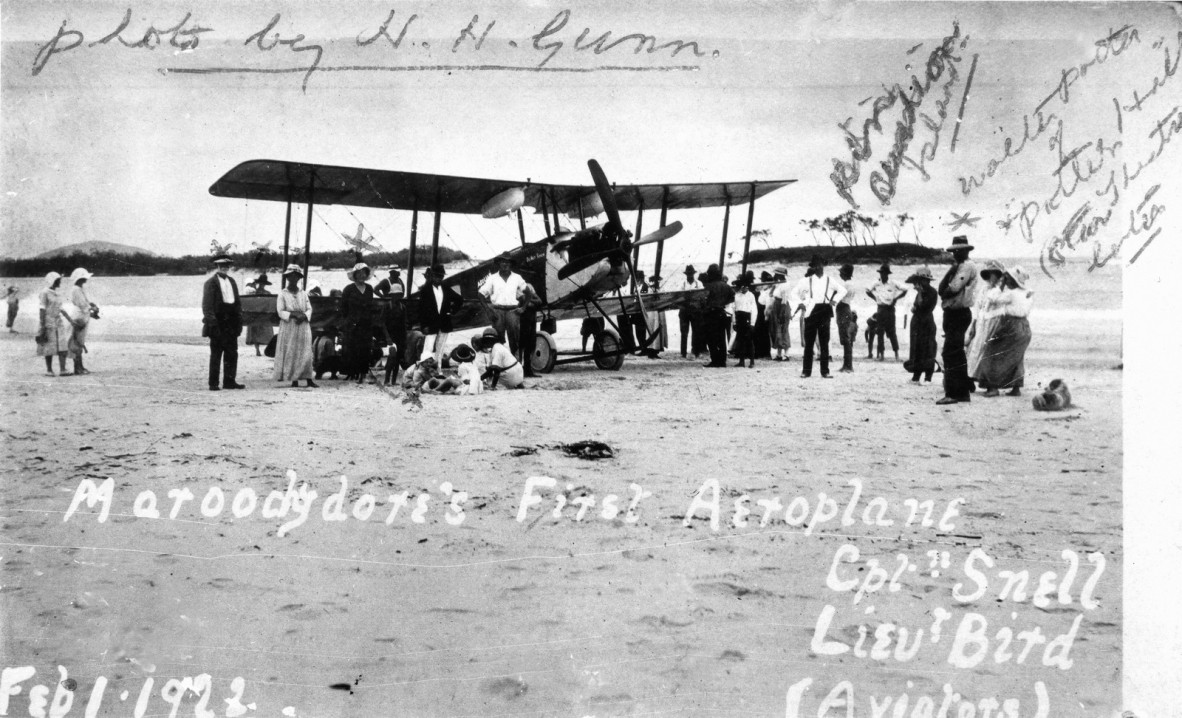 a bi-plane on the beach at Maroochydore, surrounded by onlookers