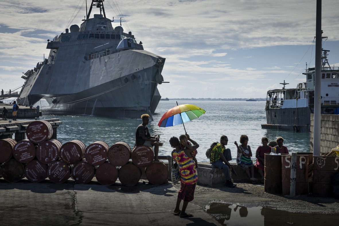 A photo of Solomon Islanders gathered to observe the Solomons Scouts and Coastwatchers memorial service at Unity Square to commemorate the 80th anniversary of the Battle of Guadalcanal. The USS Oakland is in the background. 