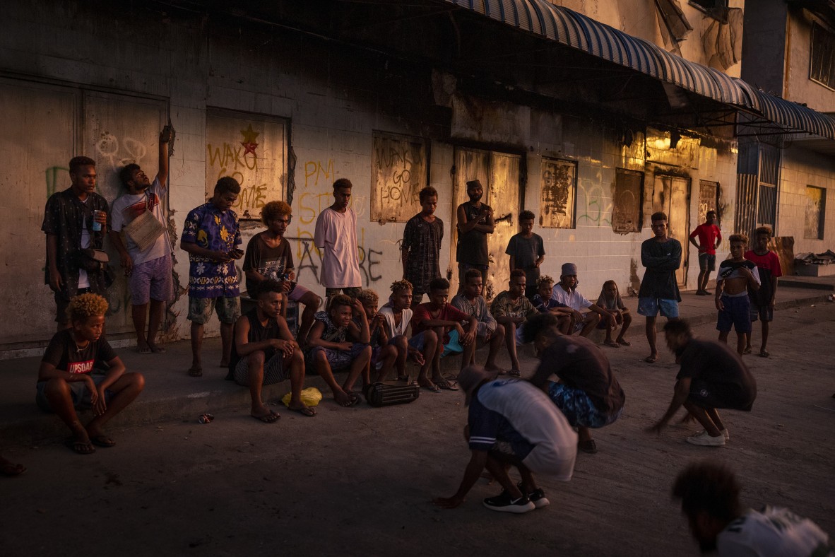 A photo of a group of young men gathered to watch and practise for a dance competition outside a destroyed building in Honiara’s Chinatown.