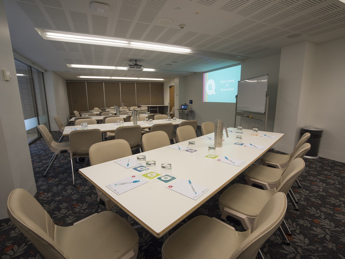 Meeting room 1B with tables, whiteboard and projector
