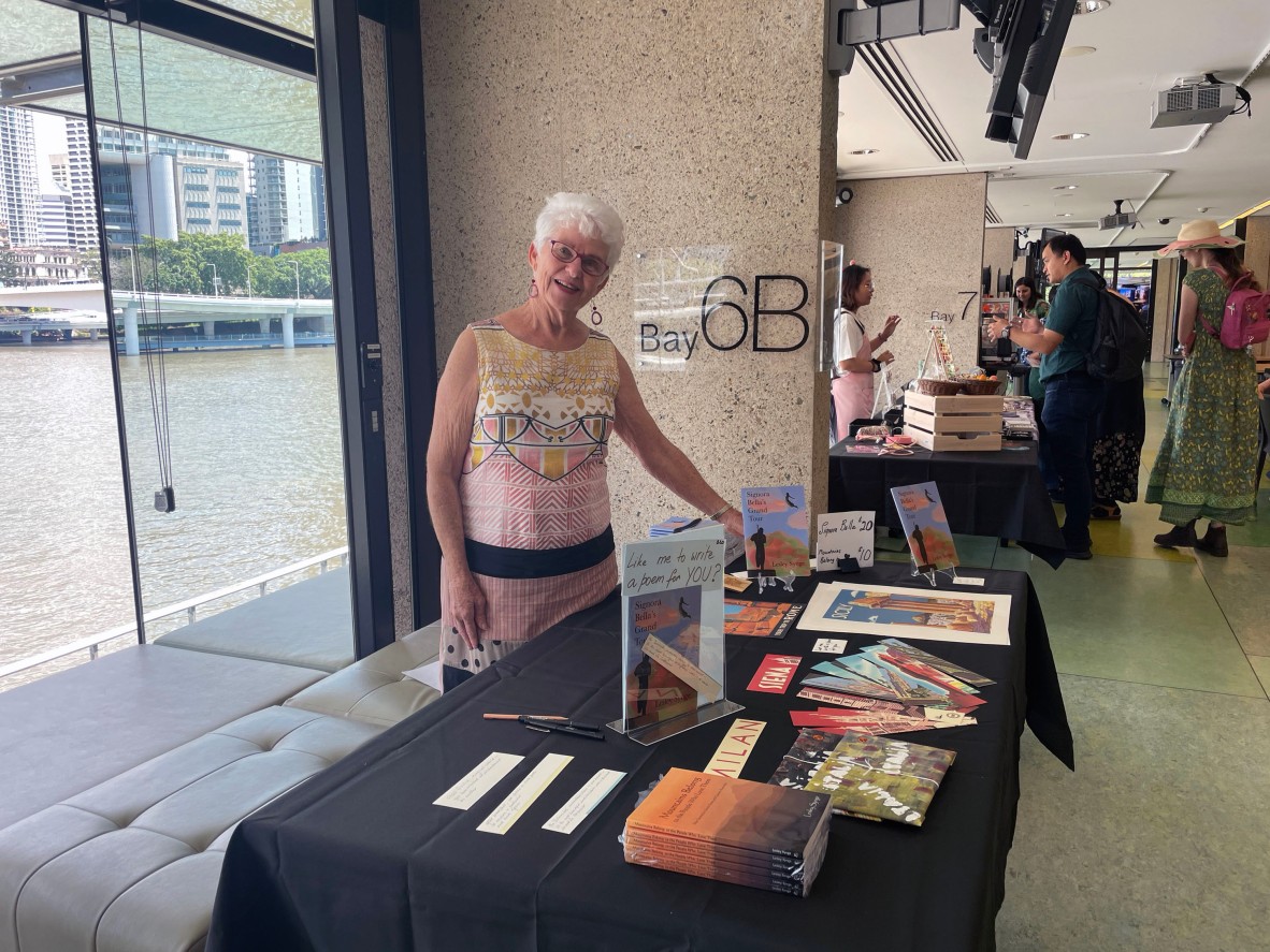 An author in front of her market stall that is full of poetry and book related items.