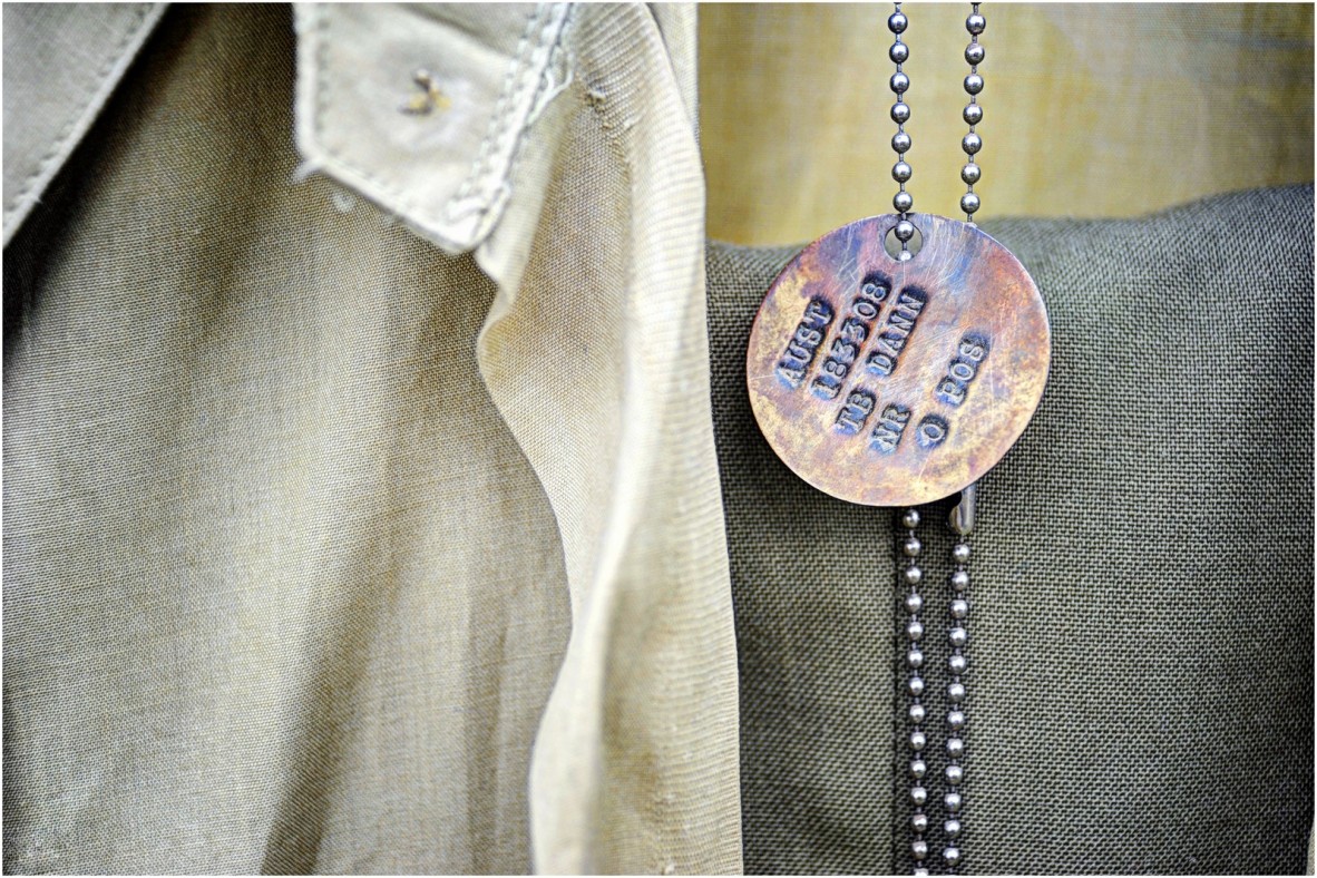 Circular identity disc on a chain. It reads 'AUST 183308 TB DANN NR O POS.'