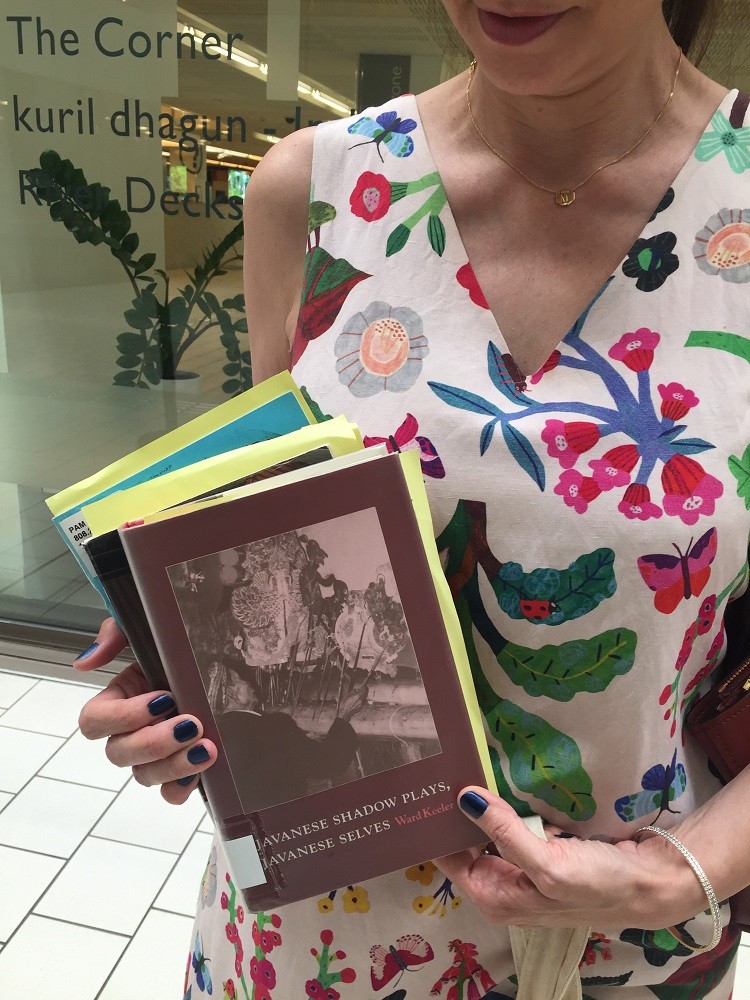 Mirandi holding a copy of her borrowed book, 'Javanese Shadow Plays, Javanese Selves'