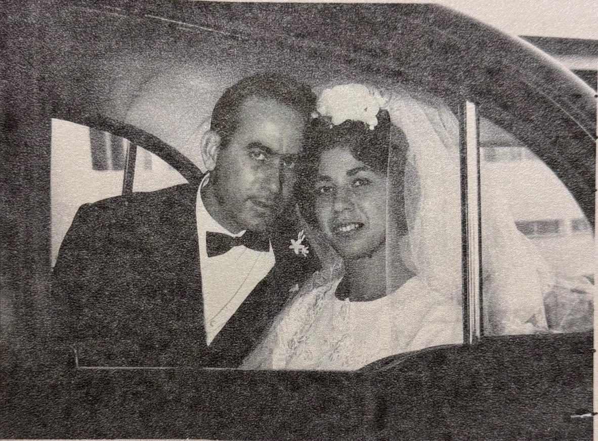 Maria and Leonardo on their wedding day in 1966. Sitting in a car looking out through the window.