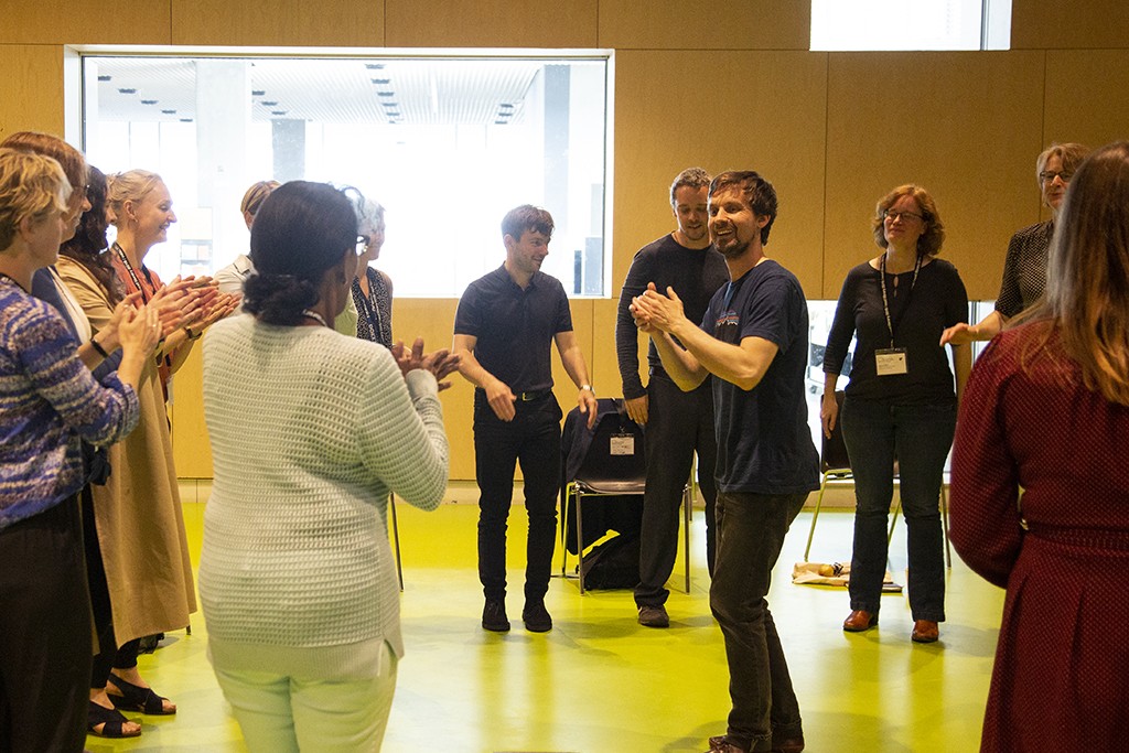 A man and a group of participants clapping.