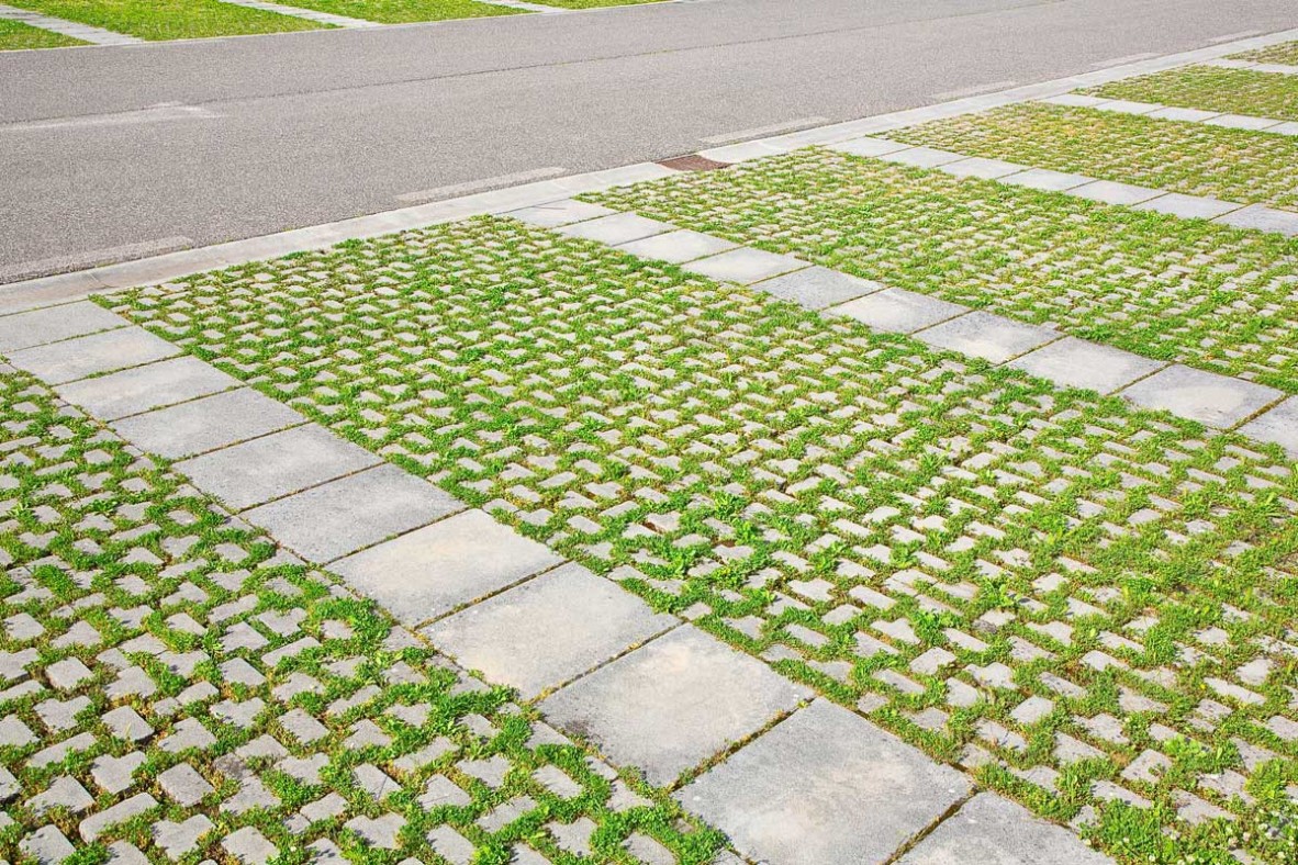 Bricks laid in open pattern with open spaces filled with soil and grass.