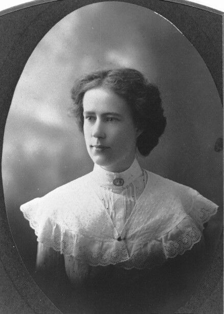 A young lady wearing a dress with a white lace collar
