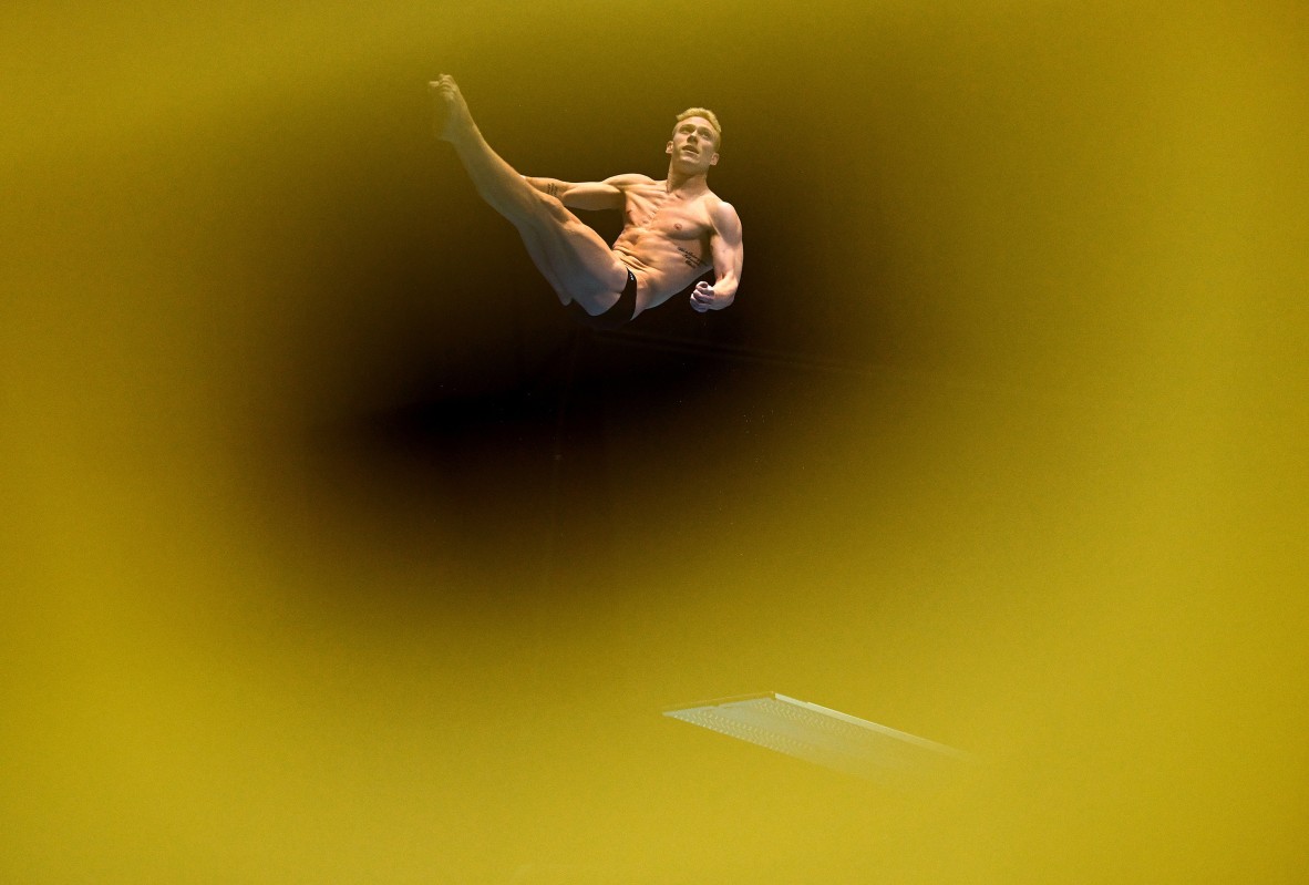 A photo of a man mid-dive with golden hue surrounding him in the photo