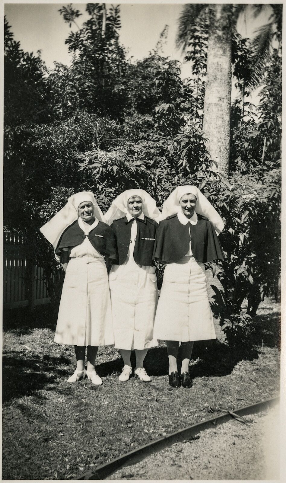 Rae Knox with 2 others in nurse's uniform posed in a garden.