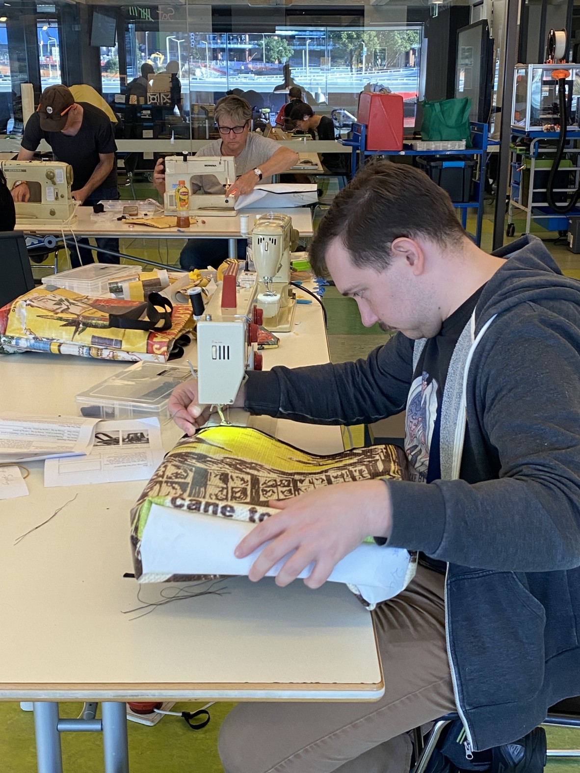 A photo of a person sewing a vinyl bag