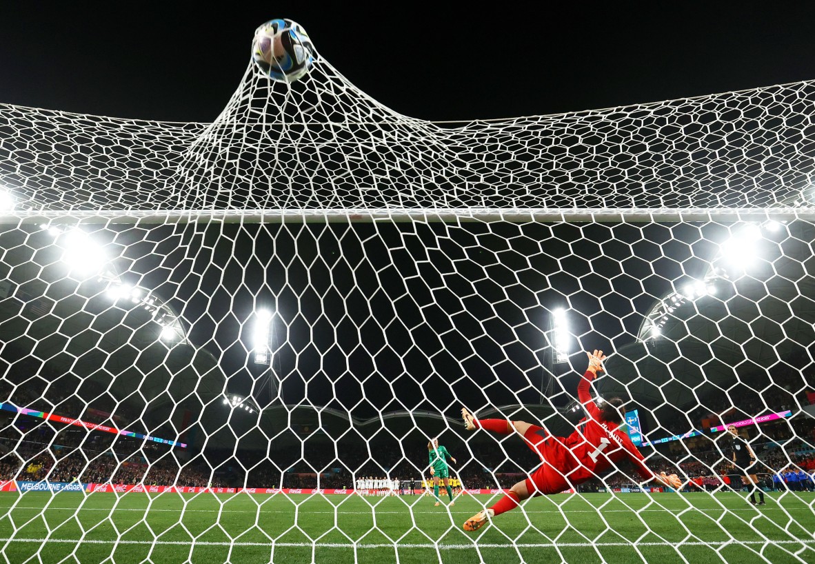 Photo of a player kicking ball into a football net 