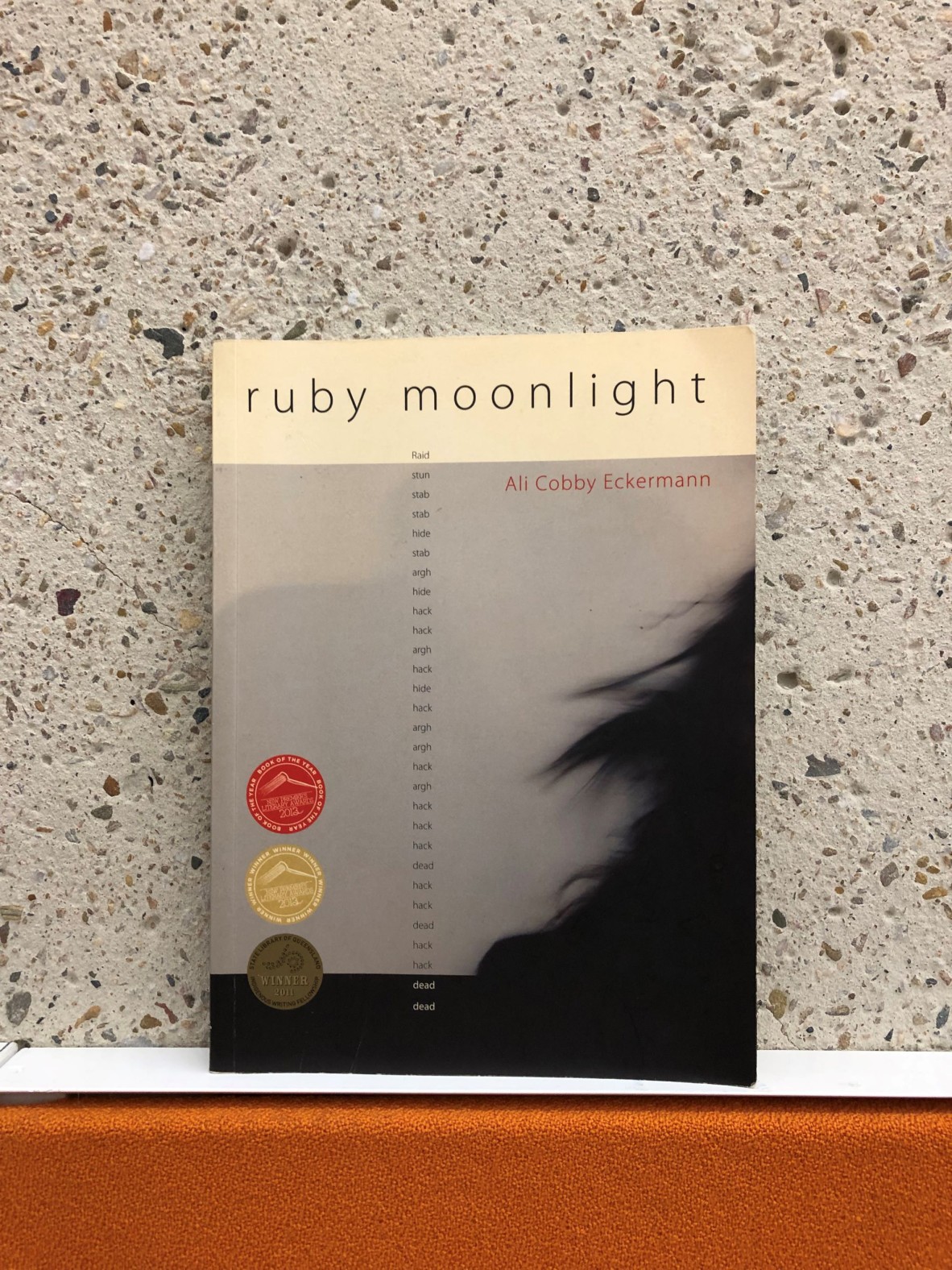 The book RUBY MOONLIGHT by Ali Cobby Eckermann on a shelf. The cover shows a girl in silhouette.