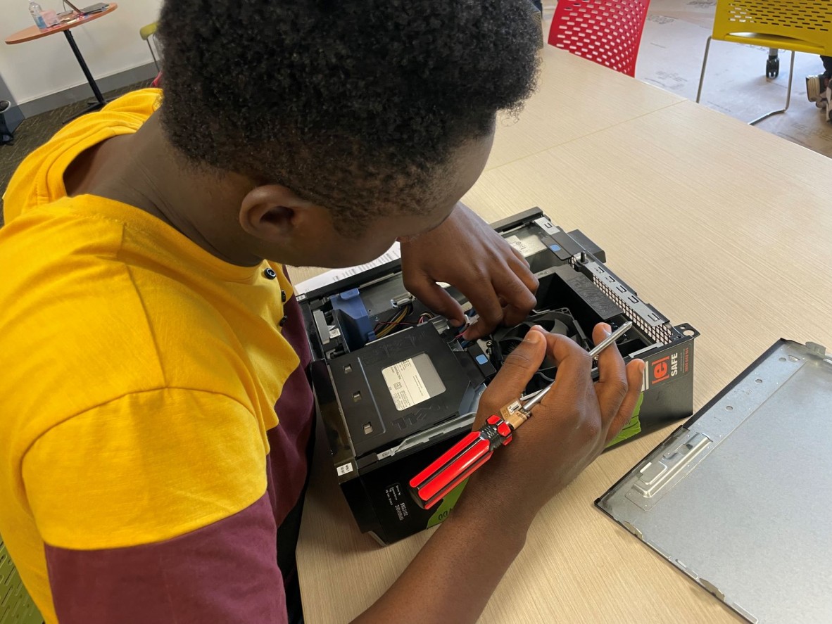 Young man works on taking apart a computer