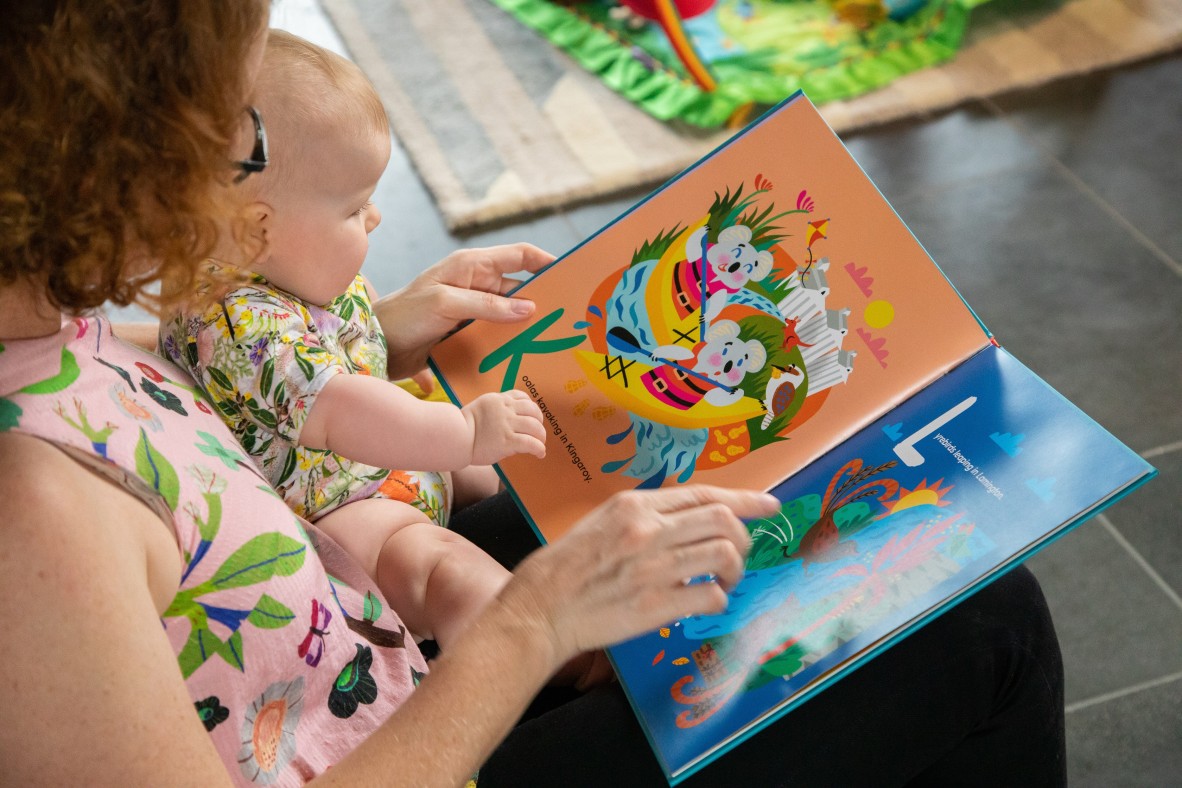 Parent and baby sharing the Little Queenslanders' Alphabet book