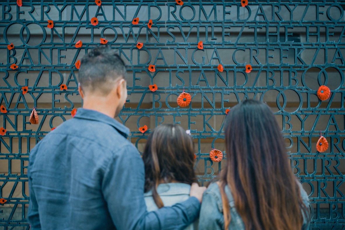 Visitors in front of bronze panels at Anzac Square