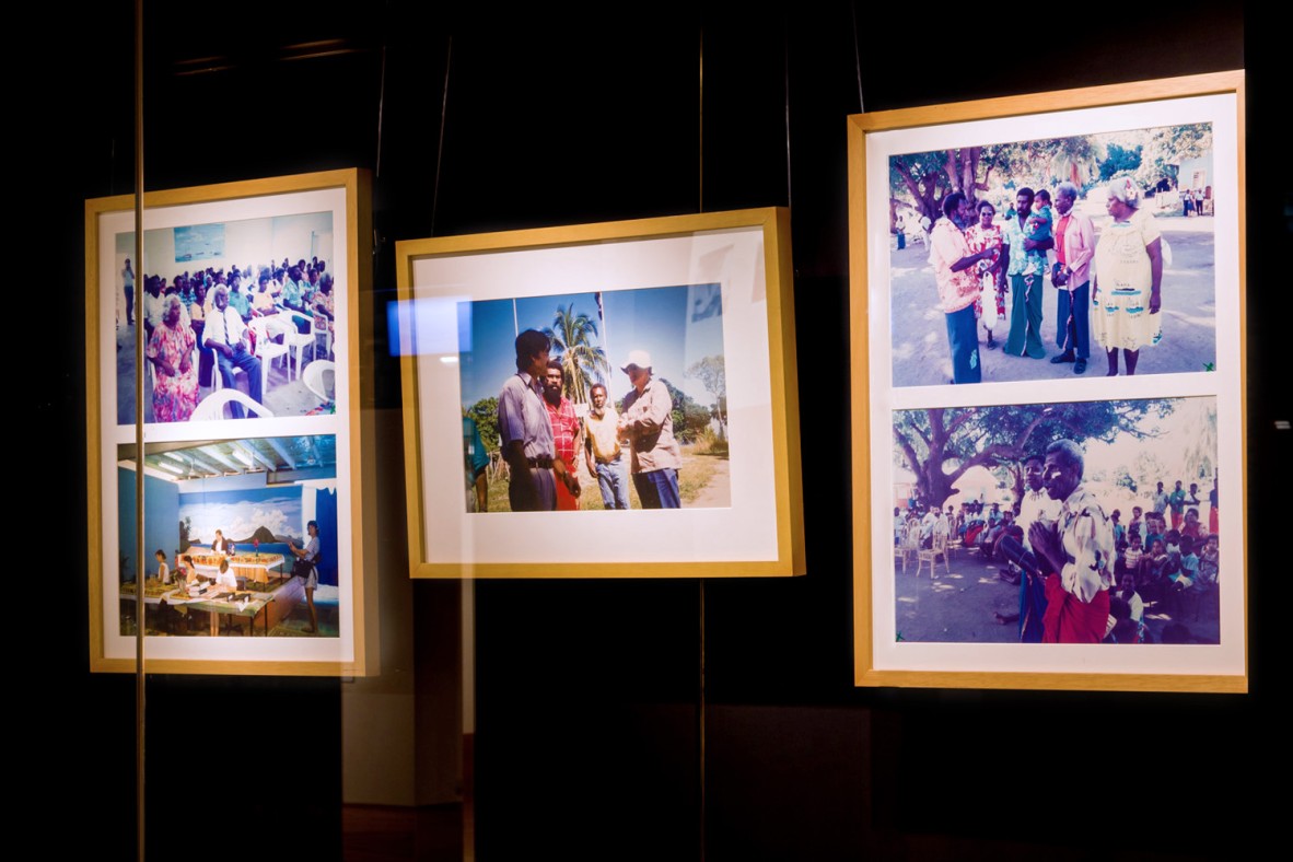 Five framed photo print reproductions hanging behind a glass cabinet.