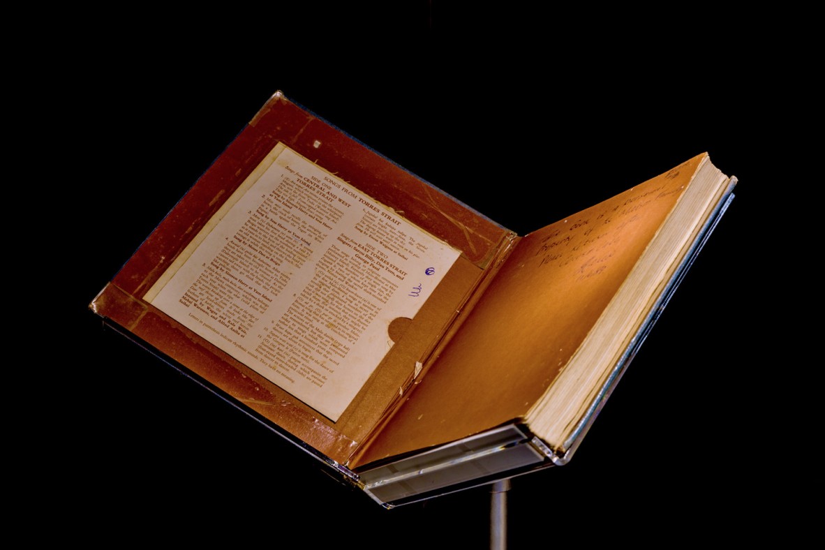 Old open book with an inscription in the front cover on display on a stand
